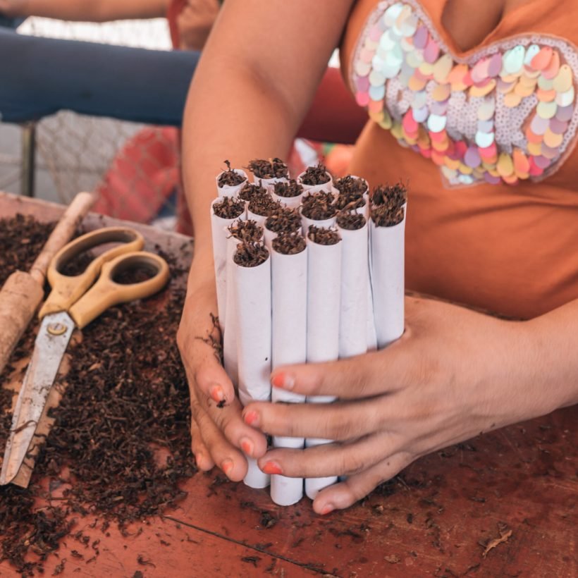 woman-s-hands-clutching-a-stack-of-handmade-cigare-2025-01-10-06-01-20-utc